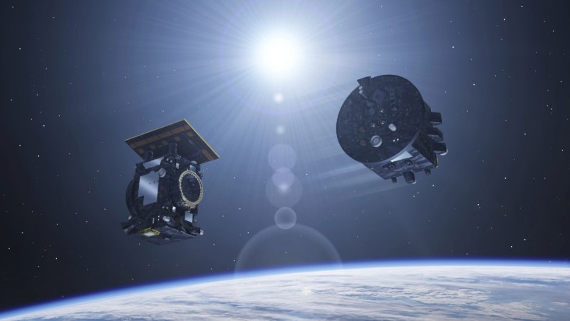 Two satellites floating above the Earth, with the sun in the background.